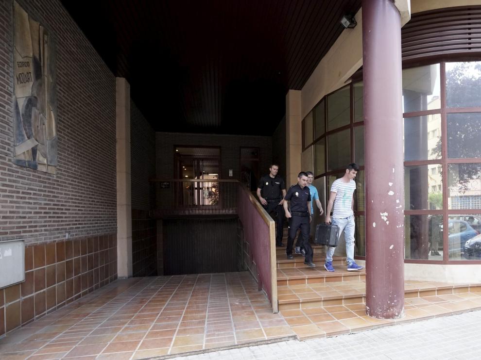 Varios policías abandonan el edificio en el que se produjeron los hechos tras inspeccionar el escenario.