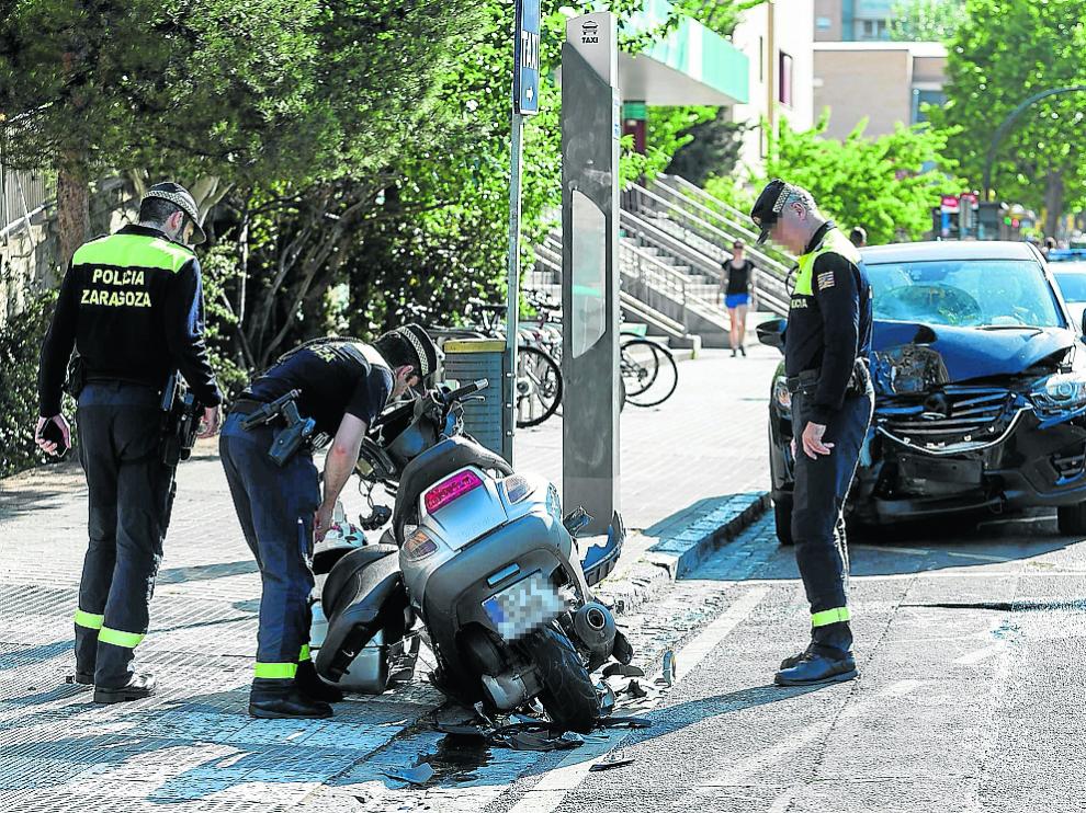 Tres agentes de la Policía Local inspeccionan la motocicleta del accidentado.