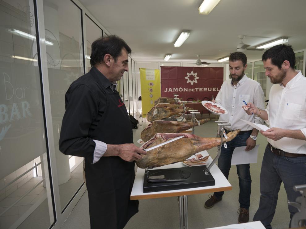Los dos catadores de la Guía Peñín examinando uno de los jamones.