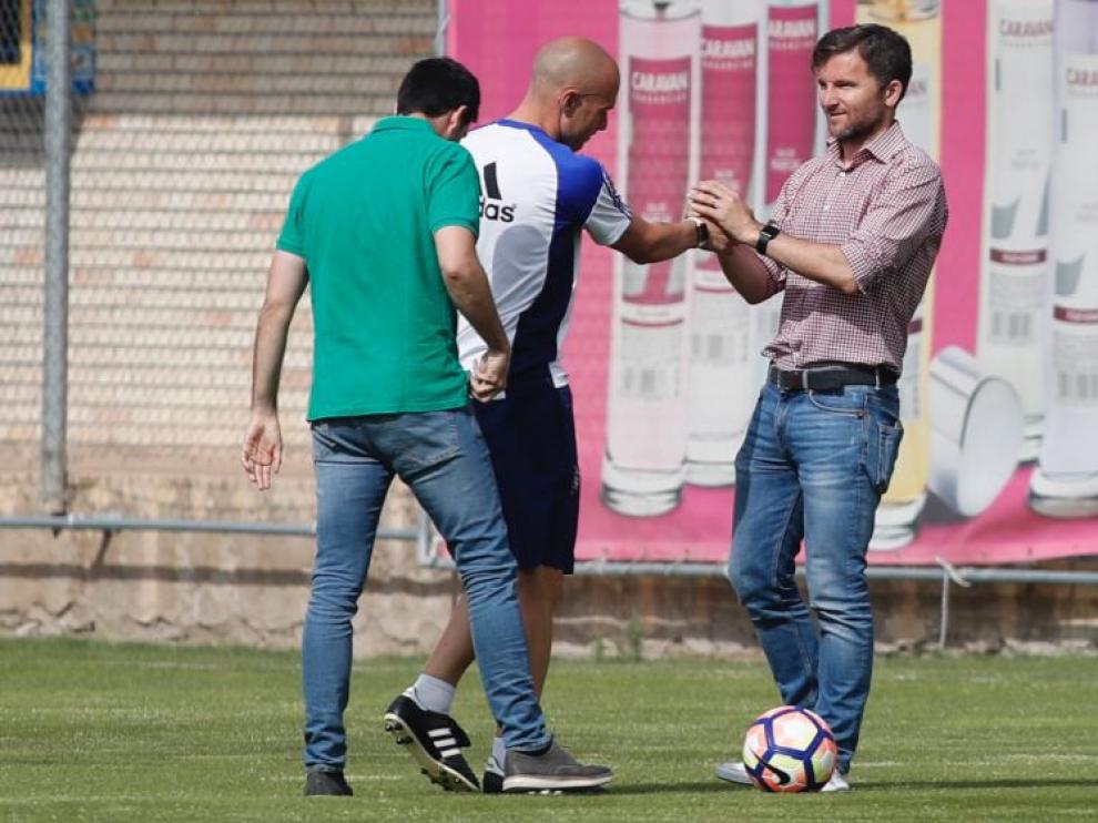 Lalo Arantegui, director deportivo del Real Zaragoza, saluda a un serio Láinez al inicio del entrenamiento de este lunes, en presencia de José Mari Barba, el secretario técnico.