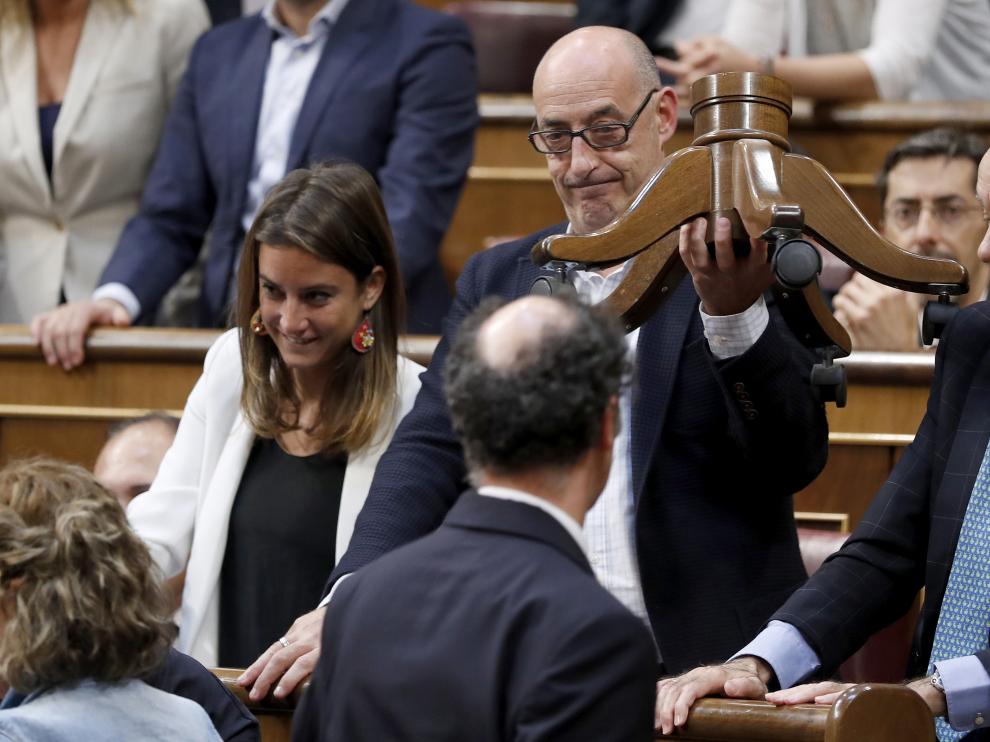 Félix Álvarez muestra los restos del escaño roto de su compañero Toni Roldán.