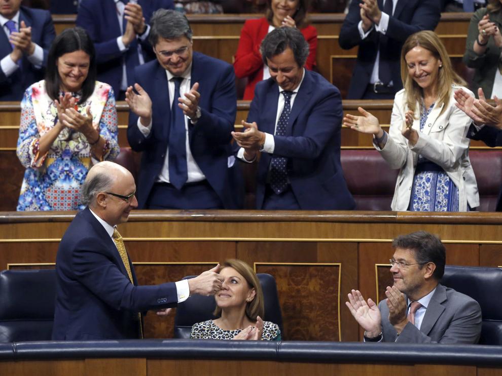 El ministro de Hacienda, Cristóbal Montoro, recibe el aplauso del PP tras la aprobación del presupuesto.