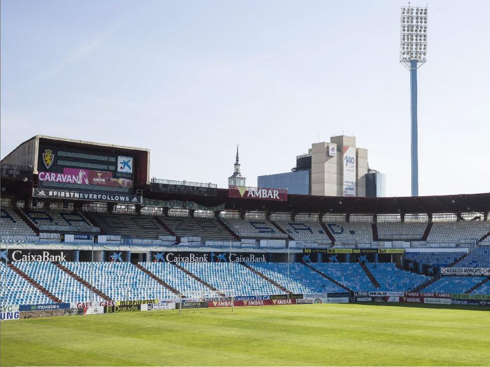 Panorámica de un tramo de tribunas de La Romareda actual, llena de publicidad con diferentes colores, de acuerdo a los logos y tonos oficiales de cada uno de los patrocinadores y sus marcas comerciales.