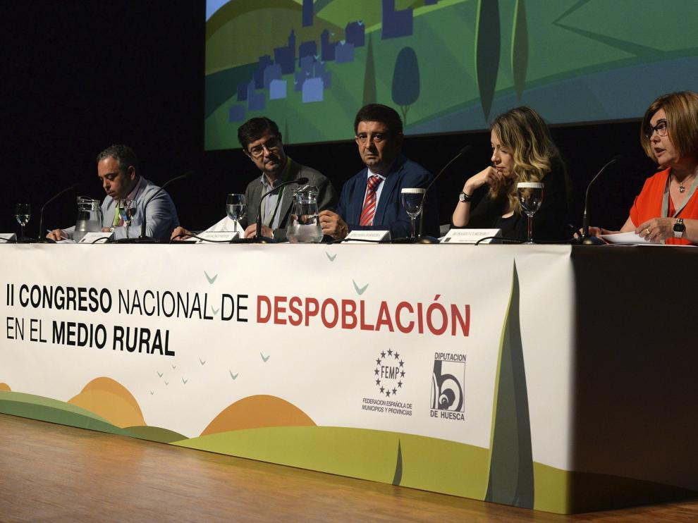 De izda. a dcha. el politólogo Roberto Pérez; Juan Ávila, de la FEMP; Francisco Reyes, de la Diputación de Jaén; Edelmira Barreira, comisionada del Gobierno; y Rosario Cordero, de la Diputación de Cáceres; durante la inauguración del II Congreso de despoblación en el medio rural que se celebra en el Palacio de Congresos de Huesca.