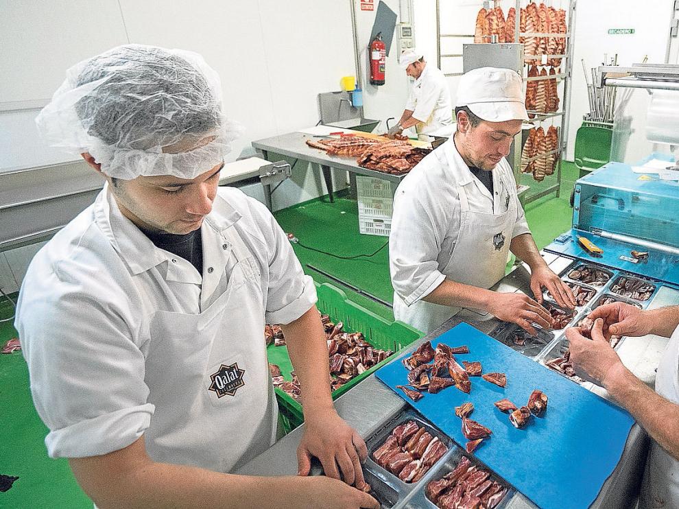 Un grupo de trabajadores de Cárnicas Santa Elena envasan productos de Denominación de Origen bajo la marca Qalat.