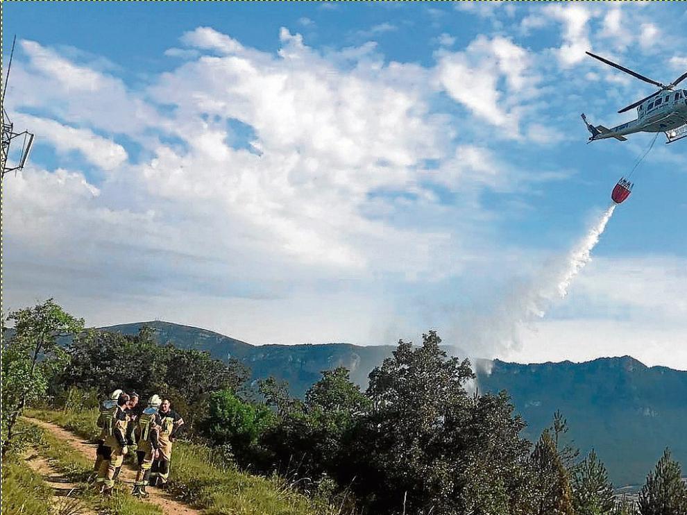 Un helicóptero soltaba ayer agua para sofocar el incendio declarado durante la madrugada en Yesa.