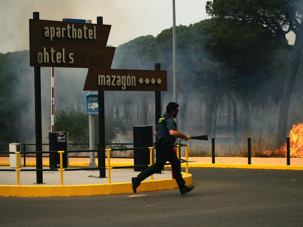 Un guardia civil intenta sofocar el fuego cerca de un bloque de partamentos.