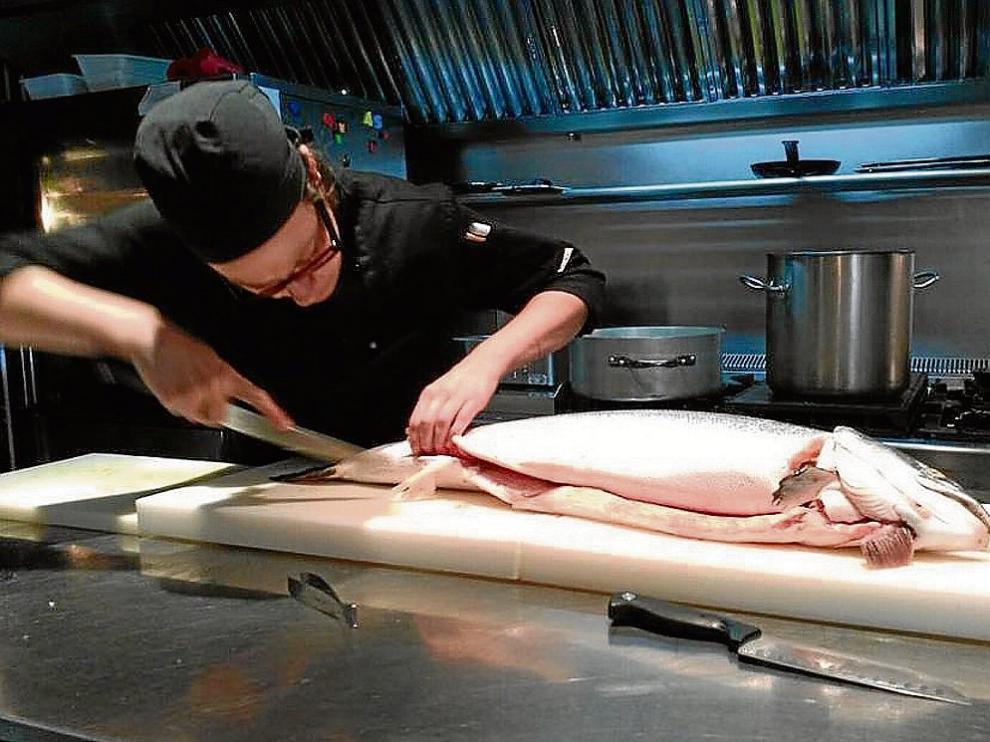 Ana Montañés prepara un salmón, en Consolación Restaurante, de Monroyo.