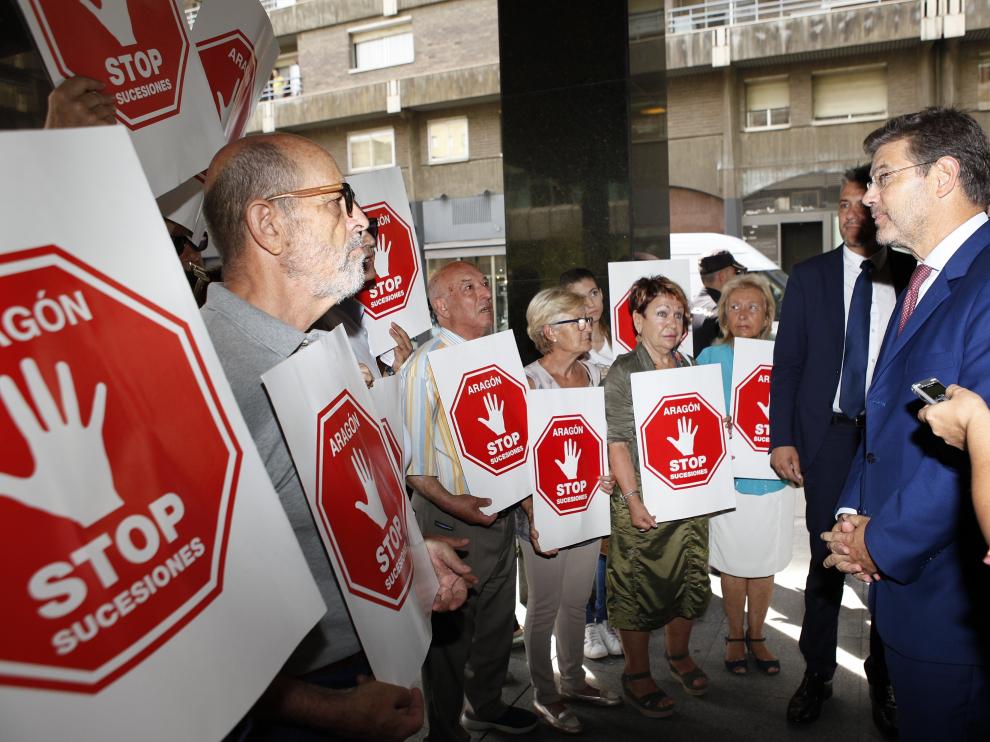 El ministro Catalá conversa con miembros de la plataforma Stop Sucesiones, este martes en Zaragoza.