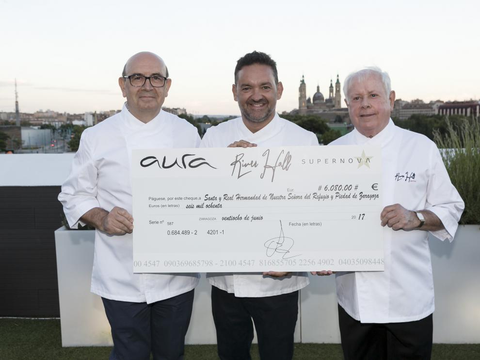 Santiago Sánchez, Iván Acedo y Manuel Marqueta, con el cheque solidario.