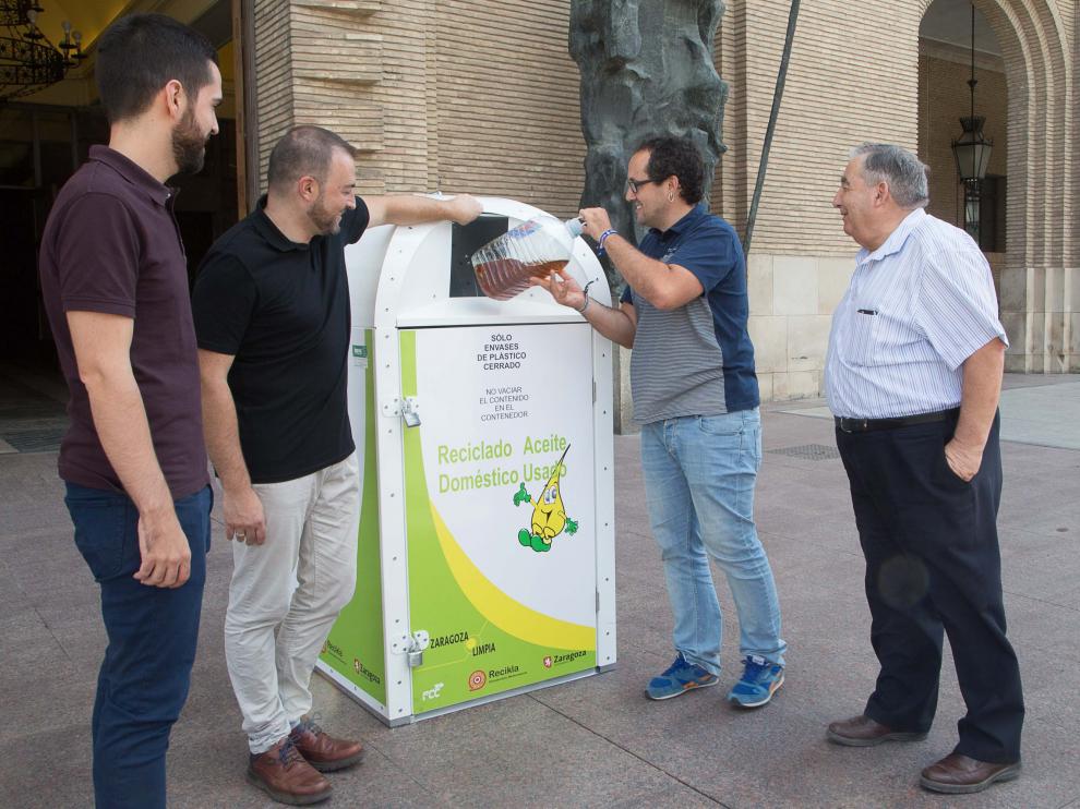 El consejero de Servicios Públicos, Alberto Cubero, recicla aceite en un contenedor junto al presidente de Adislaf, José María López (a la derecha).