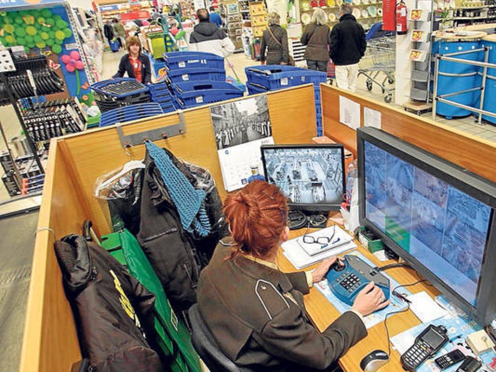 Una vigilante se ocupa de observar las cámaras de seguridad en una superficie comercial.