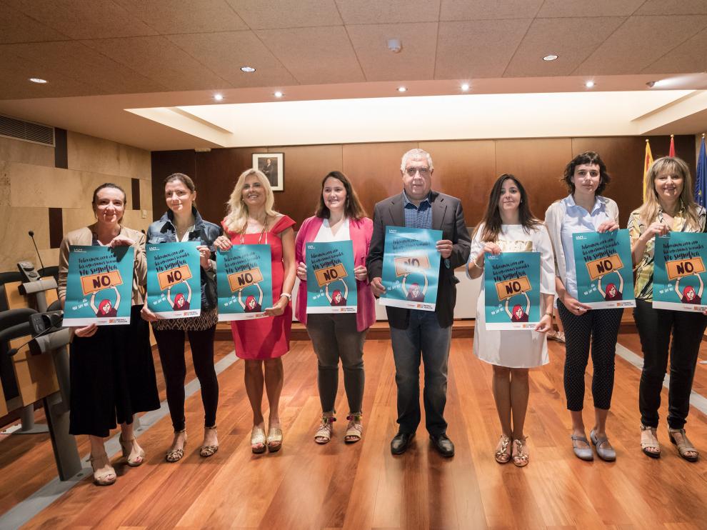Responsables de las entidades que participan en la acción, con los carteles de la campaña.