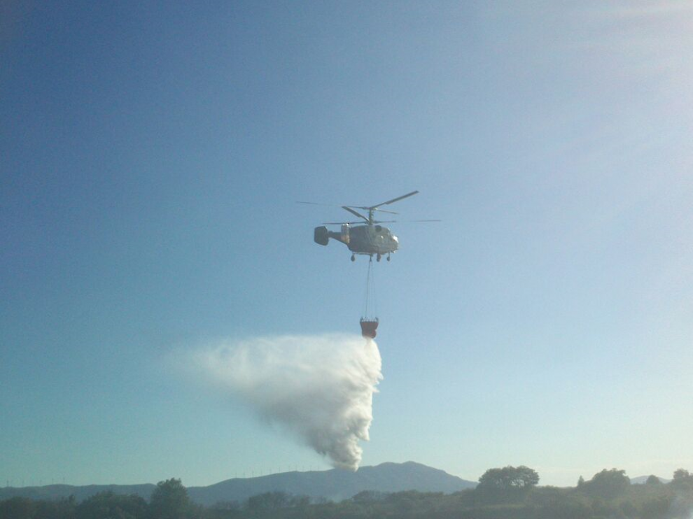 Un helicóptero trabaja en las labores de extinción del incendio.