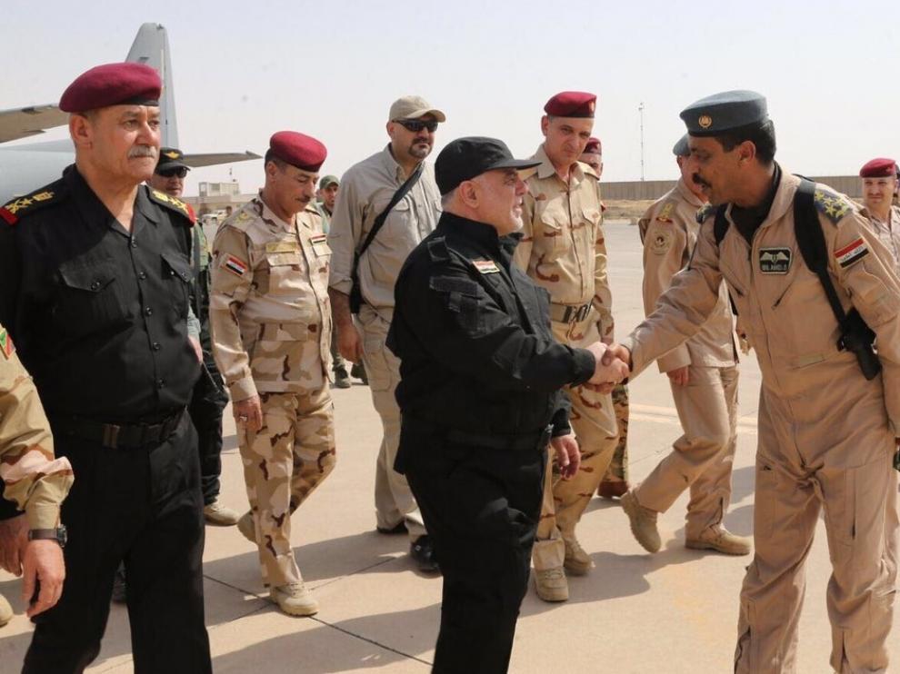 El primer ministro iraquí, Haider al Abadi, da la mano a un alto cargo del ejército.
