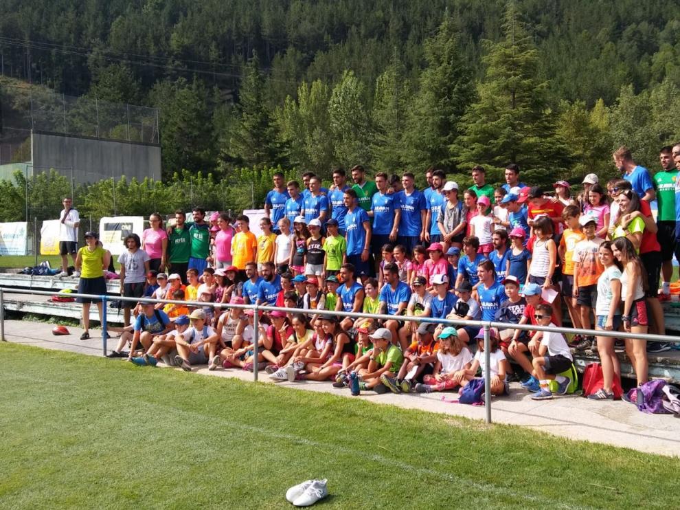 La plantilla del Real Zaragoza posa con los niños y monitores del Campamento-Colonia Multiaventura Boltaña a la conclusion del entrenamiento matinal de este martes.