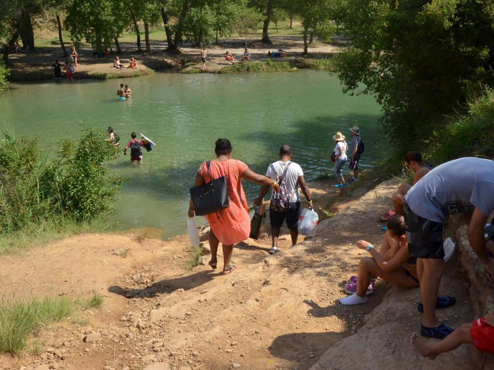Algunos bañistas que acuden al salto de Bierge cruzan el río para encontrar el mejor sitio.