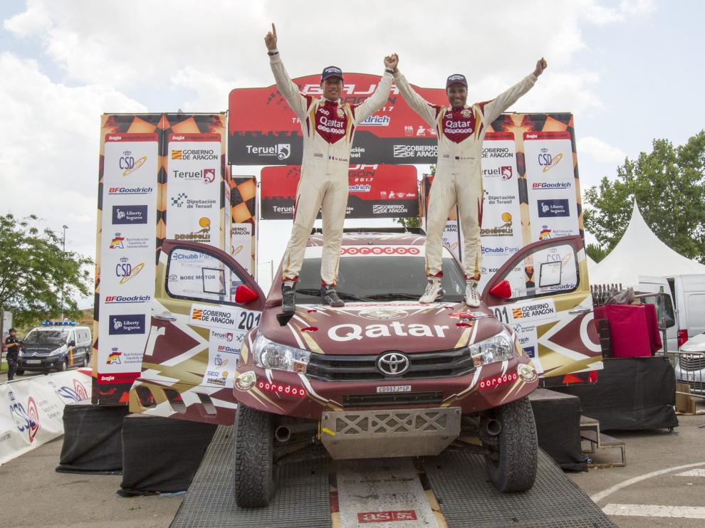 Nasser Al Attiyah celebra su triunfo en la prueba aragonesa junto a su copiloto, Mathieu Baumel, encima de su coche, un Toyota Hilux.