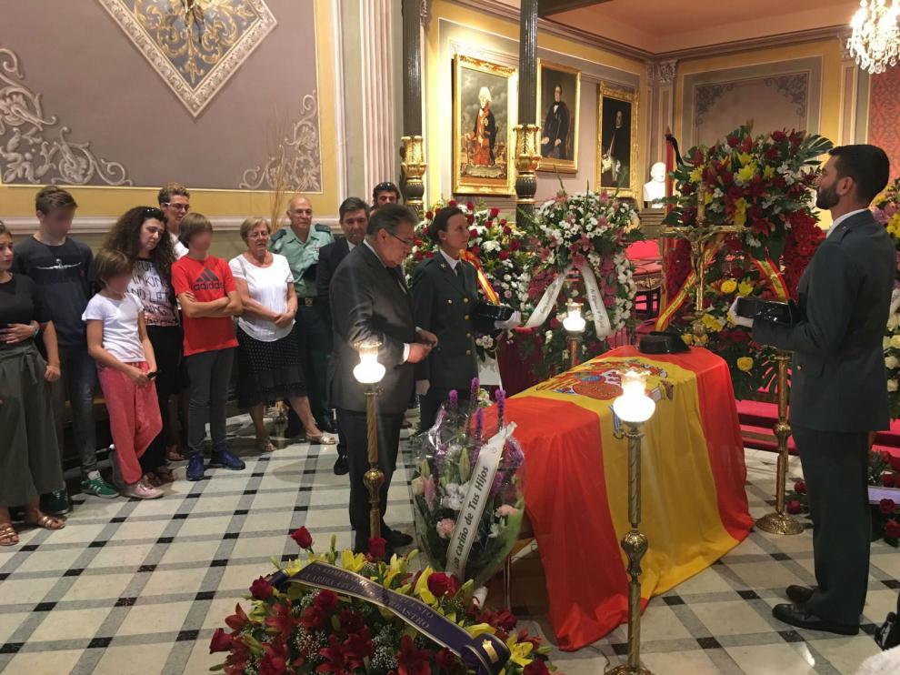 El ministro, en la visita a la capilla ardiente, imponiéndole la condecoración en presencia de la familia del guardia civil fallecido.
