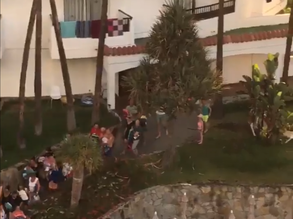 Decenas de turistas corren para reservar tumbonas en la piscina de un hotel.