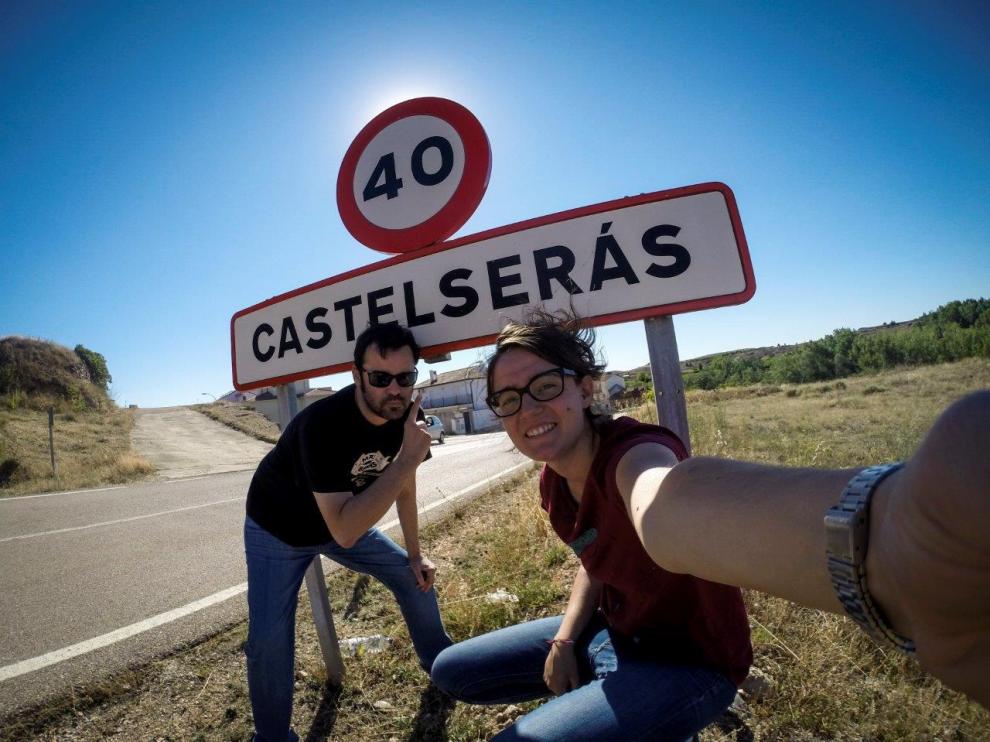 Laura Uranga y Pablo Ferrer junto al cartel de entrada a Castelserás