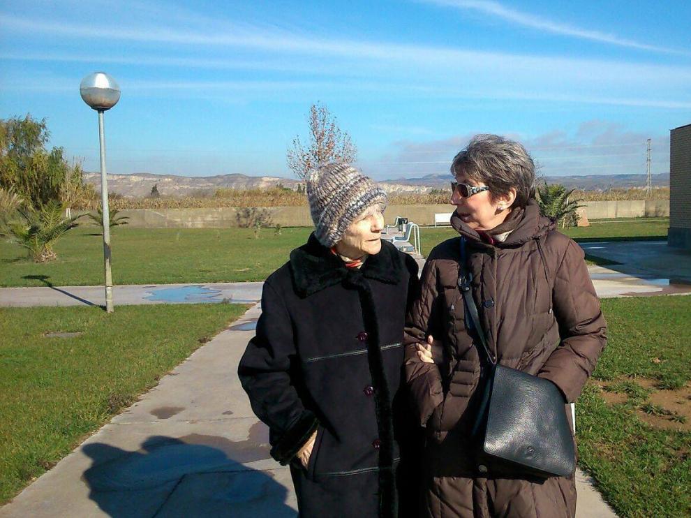 Blanca Bueno, de 86 años y enferma de alzhéimer, pasea del brazo de su hija Carmen, ya jubilada.