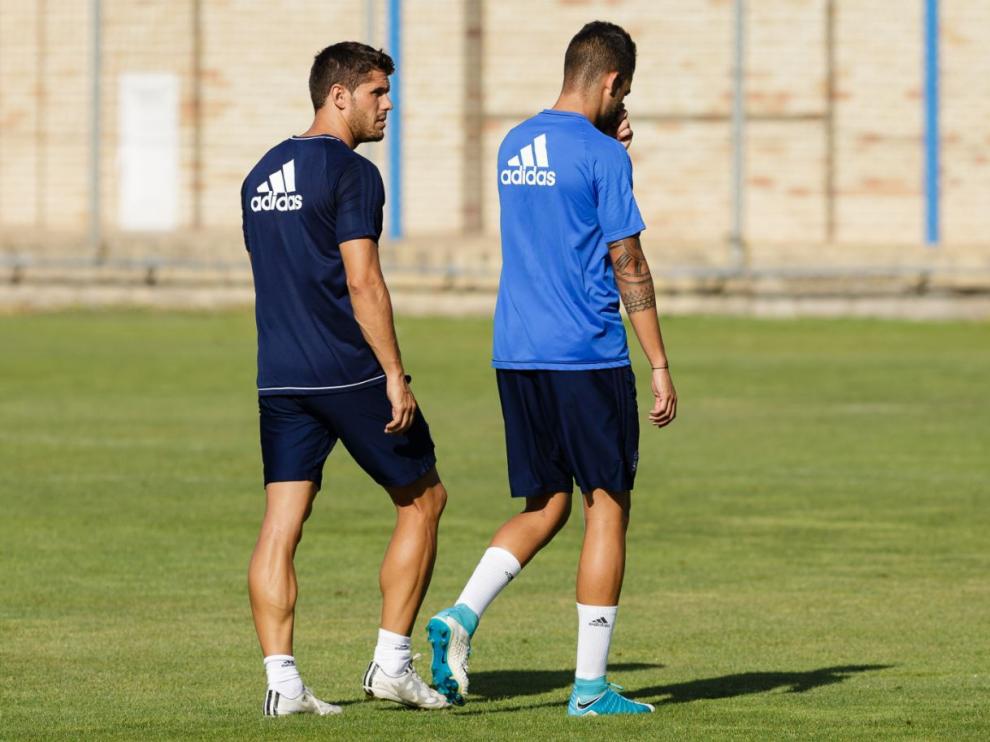 Alain Oyarzun (dcha.), con gesto torcido, se marcha del entrenamiento de este jueves acompañado del preparador físico, Javier Chocarro (izda.)