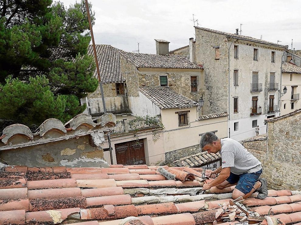 Un albañil repara un tejado de Rubielos dañado por la granizada del pasado día 23.