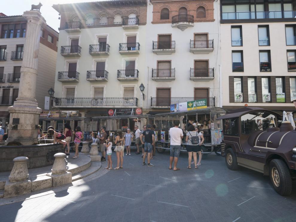 Un grupo de visitantes baja del tren turístico en la plaza del Torico tras el recorrido por los lugares más destacados de la ciudad.