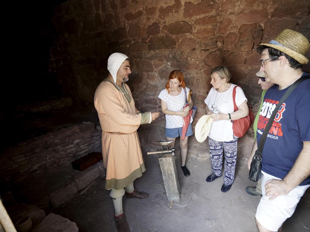 Un recreacionista muestra a los visitantes cómo funcionaba una ceca en el siglo XIII.