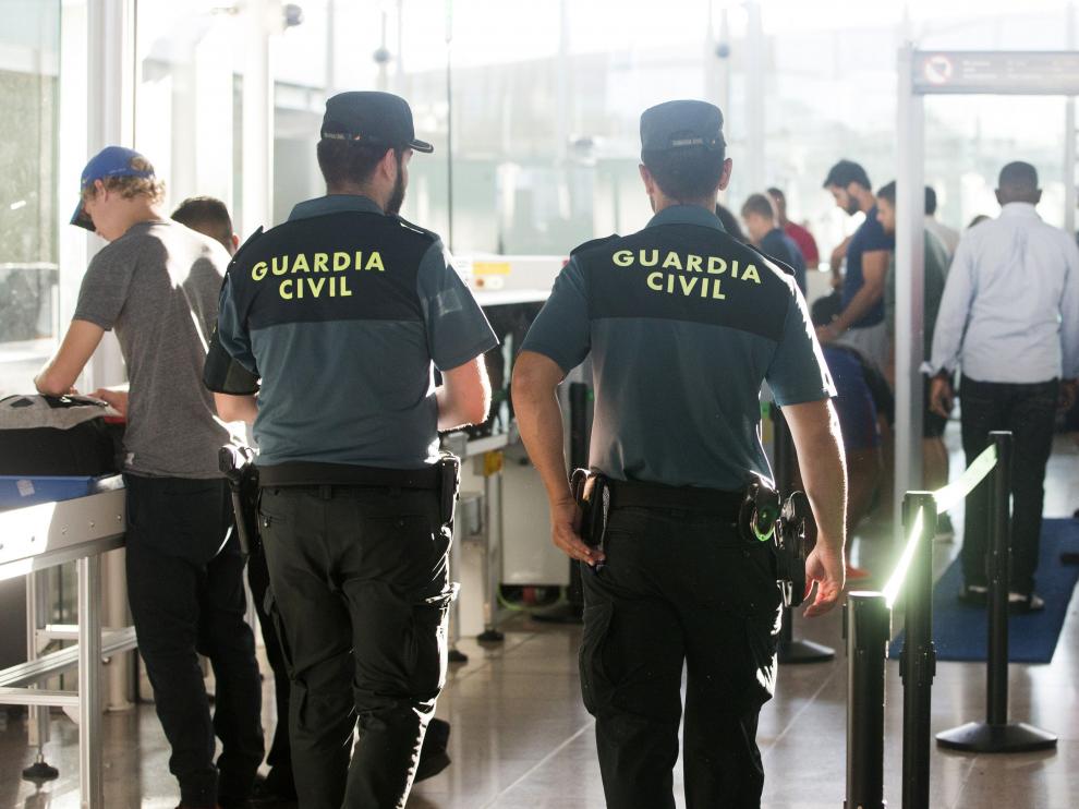 Agentes de la Guardia Civil custodian los accesos a las puertas de embarque en el aeropuerto de Barcelona tras iniciarse a medianoche la huelga indefinida de los trabajadores de Eulen, para la que el Gobierno ha decretado unos servicios mínimos del 90 por ciento. En las líneas de control de los pasajeros que acceden a la instalación se han situado ya efectivos de la Guardia Civil, que refuerzan el servicio prestado por los empleados de Eulen después de que el Gobierno tomara esta decisión para minimizar los problemas de seguridad y orden público que podrían producirse en El Prat debido a la huelga.