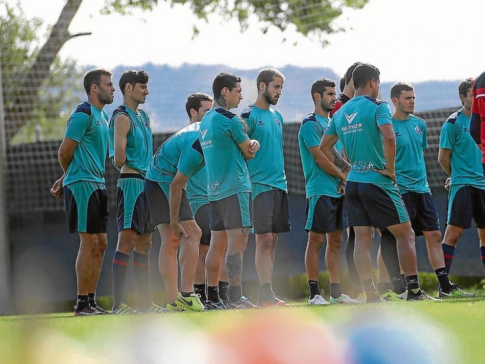 Los futbolistas del Huesca escuchan las explicaciones de los técnicos nada más arrancar la sesión de ayer en el Montearagón.