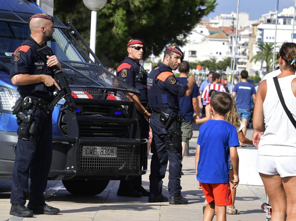 Varios policías armados vigilan ayer en Cambrils ante el paso de los turistas.