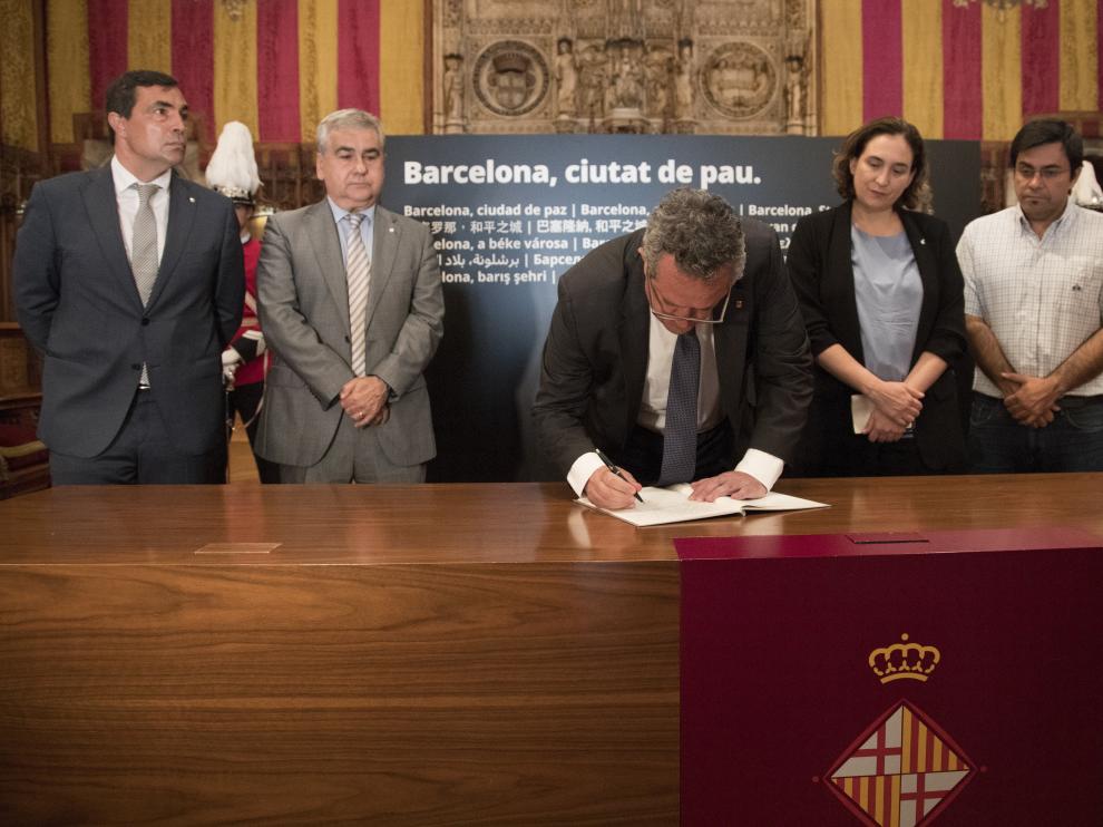 El consejero de Interior, Joaquim Forn, firma en el libro de condolencias del Ayuntamiento de Barcelona.