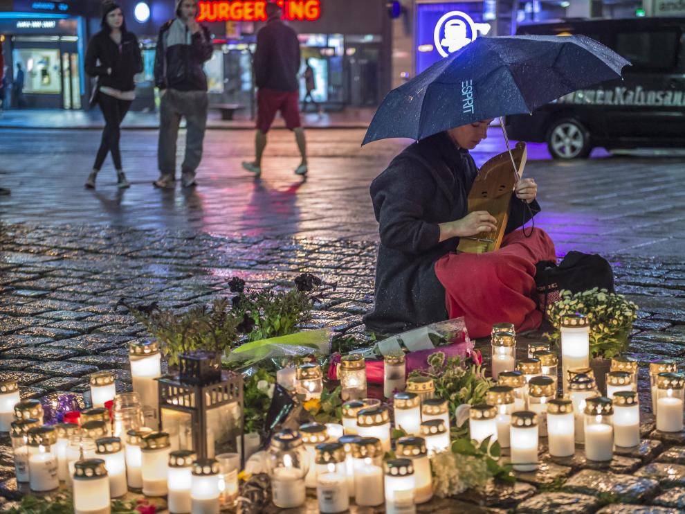 Una joven presenta sus condolencias en un altar improvisado en la calle
