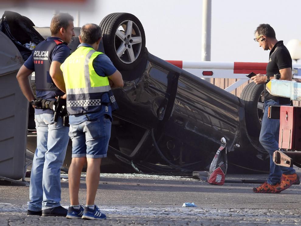 Agentes de los Mossos d'Esquadra examinan el vehículo Audi A3 donde iban los cinco terroristas, en el paseo marítimo de Cambrils.