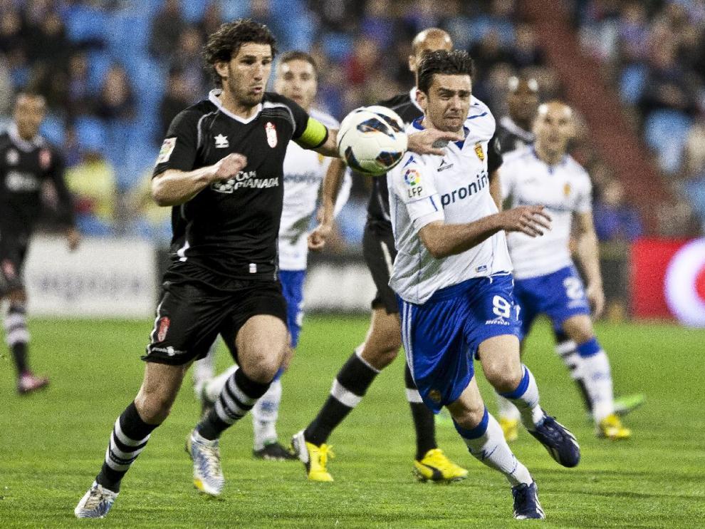 Hélder Postiga pugna con un defensor del Granada en el último partido entre ambos equipos, en marzo de 2013. Detrás asoman Movilla y Rochina.