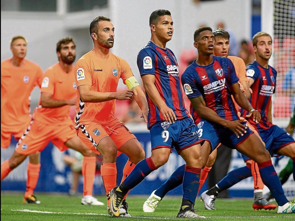 Cucho Hernández, Jair Amador y Jorge Pulido esperan la pelota en un corner favorable durante el Huesca-Lorca.