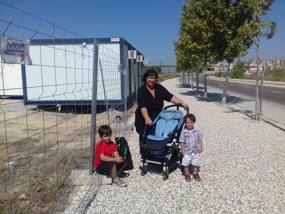 Rosana Rodríguez, con sus dos hijos, ante el solar del futuro colegio de Parque Venecia. Sus hijos estarán escolarizados en colegios diferentes por el retraso de las obras.