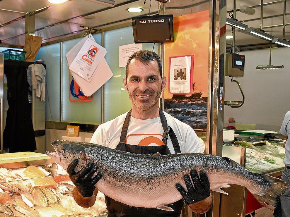 Alberto Lallana, de Pescados Cañete, en el Mercado de San Vicente de Paúl de Zaragoza, con un bonito ejemplar de salmón.