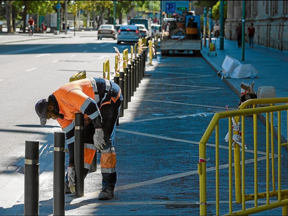 Un trabajador de la contrata Inviasa ajusta un bolardo en la parte trasera de la basílica del Pilar.
