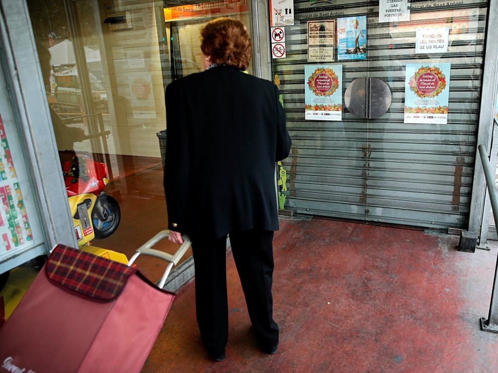 Una mujer ante las puertas cerradas en el mercado de San Antoni