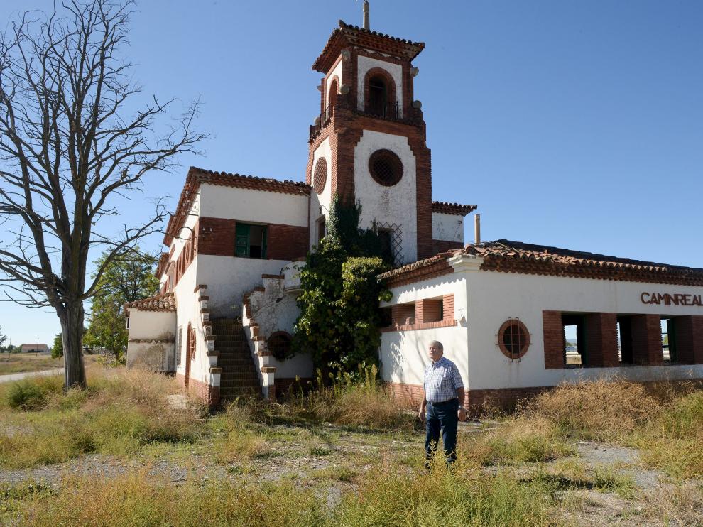 El alcalde de Caminreal, Joaquín Romero, delante del edificio de la estación, que tiene una torre.