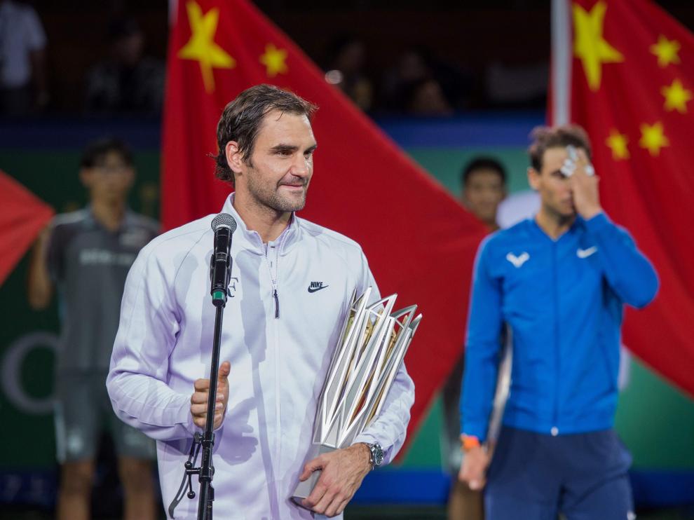 Federer, en primer plano, se dirige al público tras derrotar a Nadal, al fondo de la imagen.