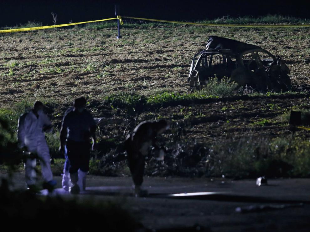 Los forenses revisan el lugar donde explotó el vehículo de la periodista.