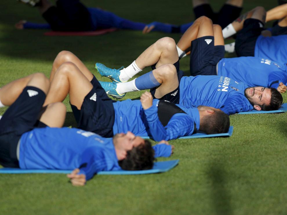 La plantilla del Real Zaragoza realiza ejercicios de estiramiento, ayer, en la Ciudad Deportiva.
