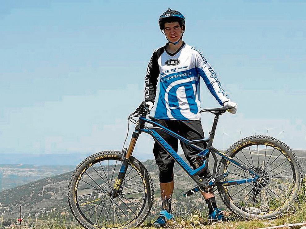 El joven Gabi Torralba posa con su bicicleta y su equipación habitual.
