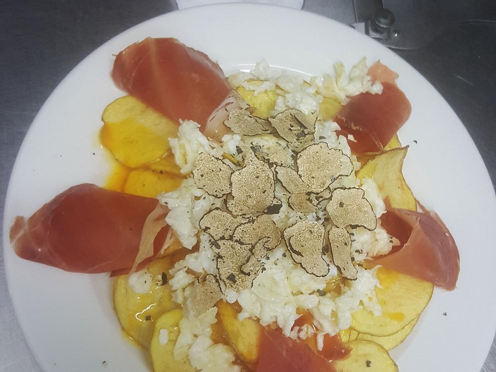 Huevos rotos con patatas chip y trufa uncinatum.