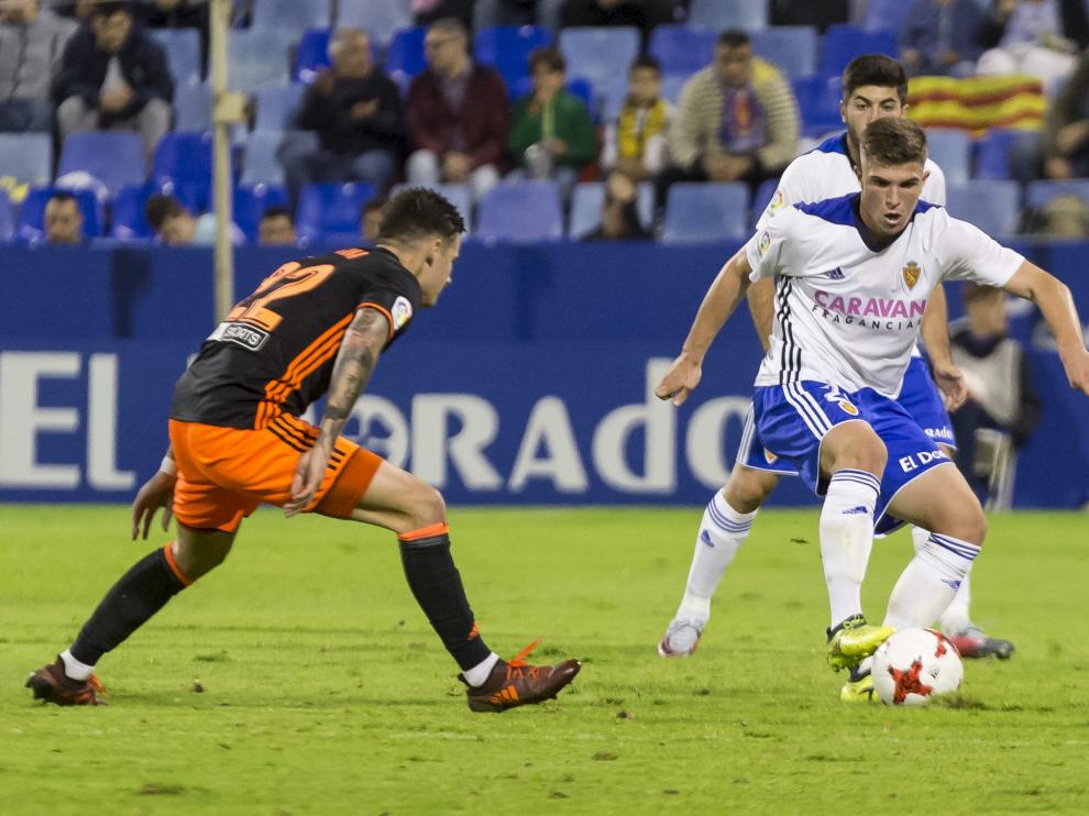 Raúl Guti, el mejor jugador sobre el campo, controla la pelota ante la vigilancia de Santi Mina.