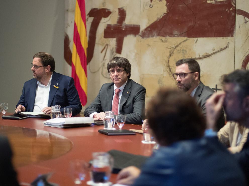 El presidente de la Generalitat, Carles Puigdemont (d) y el vicepresidente, Oriol Junqueras (i), durante la reunión semanal del gobierno catalán, a dos días de que el Parlament se reúna para acordar una respuesta a la aplicación del artículo 155 de la Constitución, asunto que analizarán en comisión los ocho senadores designados por la cámara catalana.